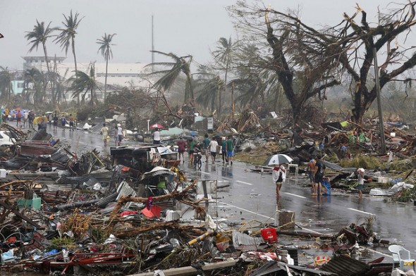 Residents walk on a road littered with debris after Super Typhoon Haiyan battered Tacloban city in central Philippines November 10, 2013. Haiyan, one of the most powerful storms ever recorded, killed at least 10,000 people in the central Philippines province of Leyte, a senior police official said on Sunday, with coastal towns and the regional capital devastated by huge waves. Super typhoon Haiyan destroyed about 70 to 80 percent of the area in its path as it tore through the province on Friday, said chief superintendent Elmer Soria, a regional police director.