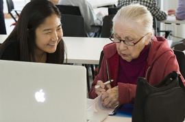 Erin Kim, a freshman at Olin, helps Dr. Elsie Meyers navigate a Macbook in the Active Learning Lab in Bauer Hall in the new “Computer Comfort” class being offered for area seniors. 