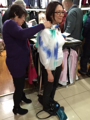 A fabric salesperson measuring Julie Thiessen for a dress. 