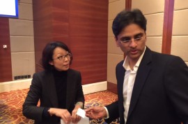 EMBA 43 student Vamsi Narra exchanges business cards with Jessie Jiang