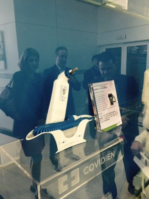 Covidien thermometer. Sales for this thermometer increased by ten times during the height of the Ebola crisis.  EMBA  43 students Laura Tellman, Tim Sims, and Jim Young are reflected in the glass case. 